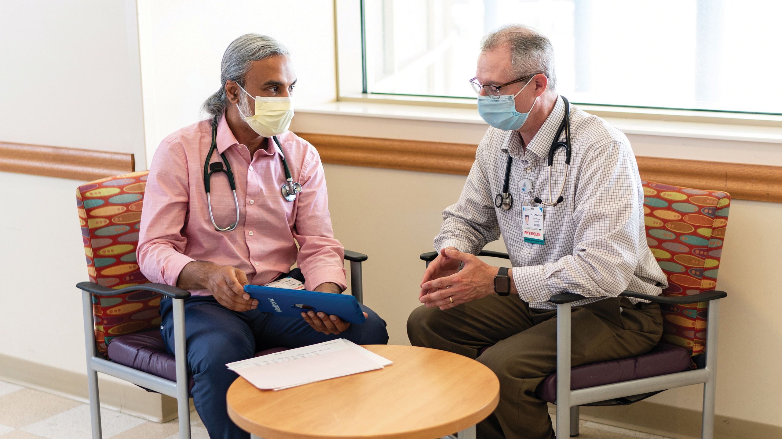 Two doctors discussing in hallway.