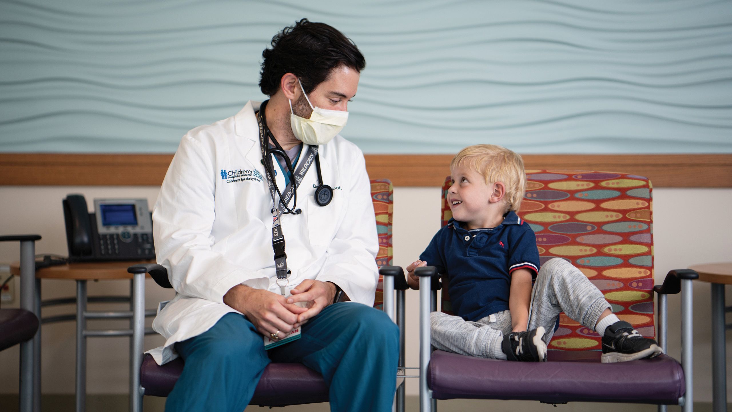 Image of doctor and child seated and smiling at each other.