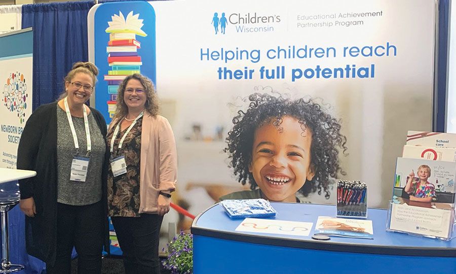 Photo of Kyle Landry and Christie Reuhl in front of booth at PAS
