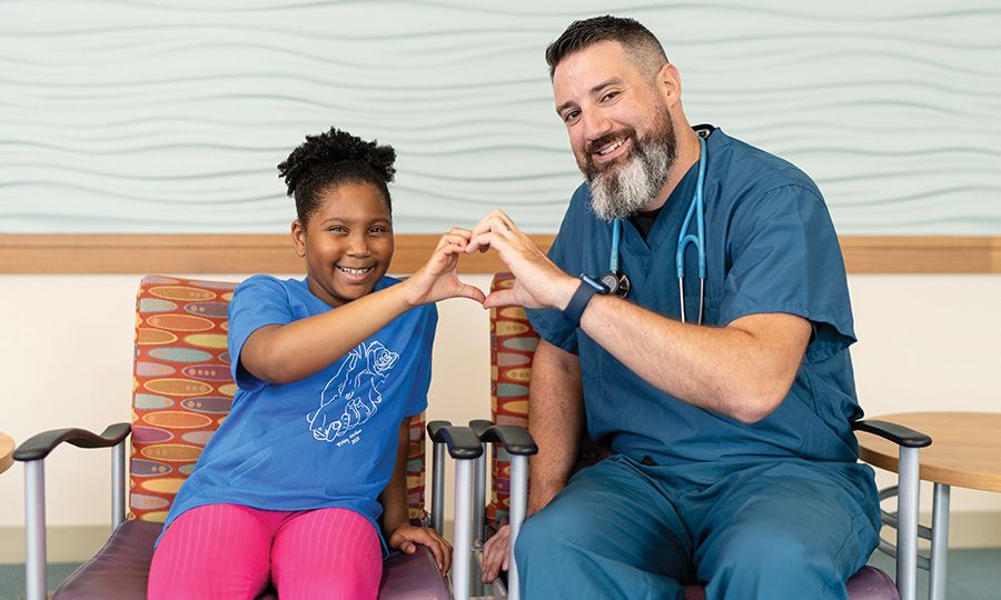 Photo of provider and kid making a heart with hands